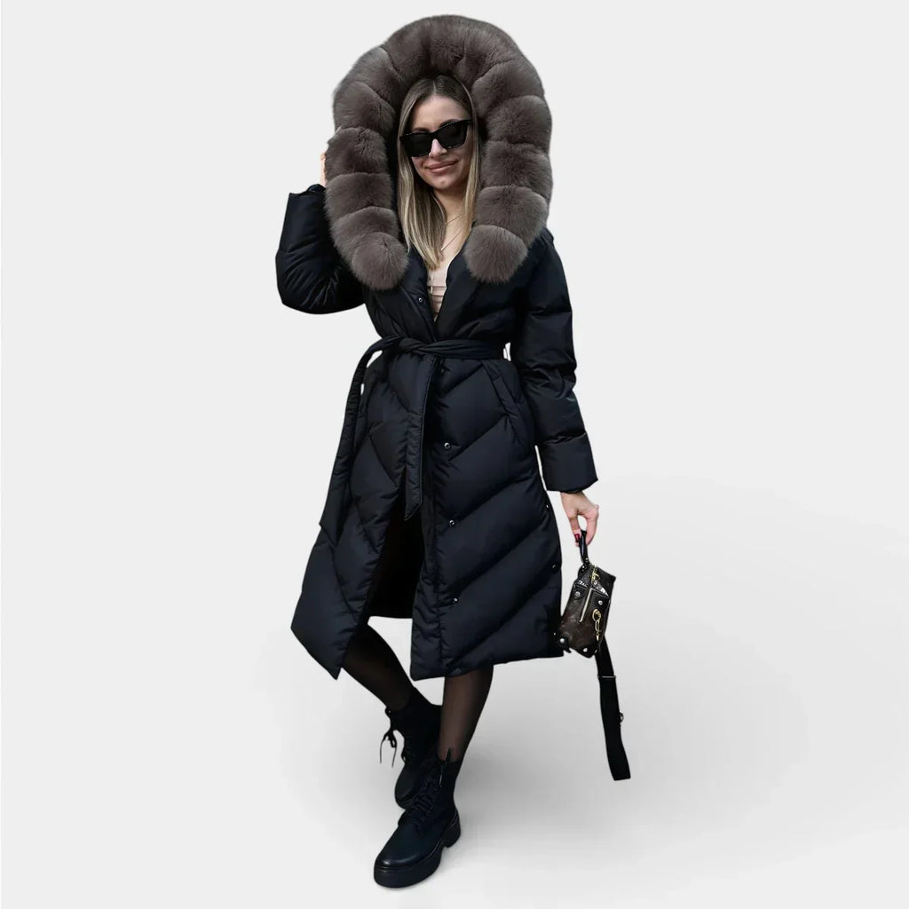 Long black puffer jacket with taupe fur hood, button front, and waist tie belt.