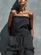 Black and white striped strapless jumpsuit with smocked bodice and ruffled tiers