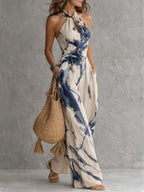 Beige halter neck wide-leg jumpsuit with blue ink-wash print, gathered waist, pockets