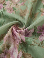 Green floral chiffon fabric close-up with pink floral print