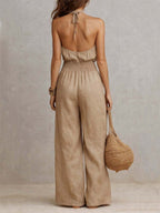 Beige halter backless jumpsuit with tie at neck, smocked waist, wide legs