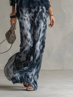 Printed wide-leg pants with flowing chiffon overlay and dark ruffled waistband