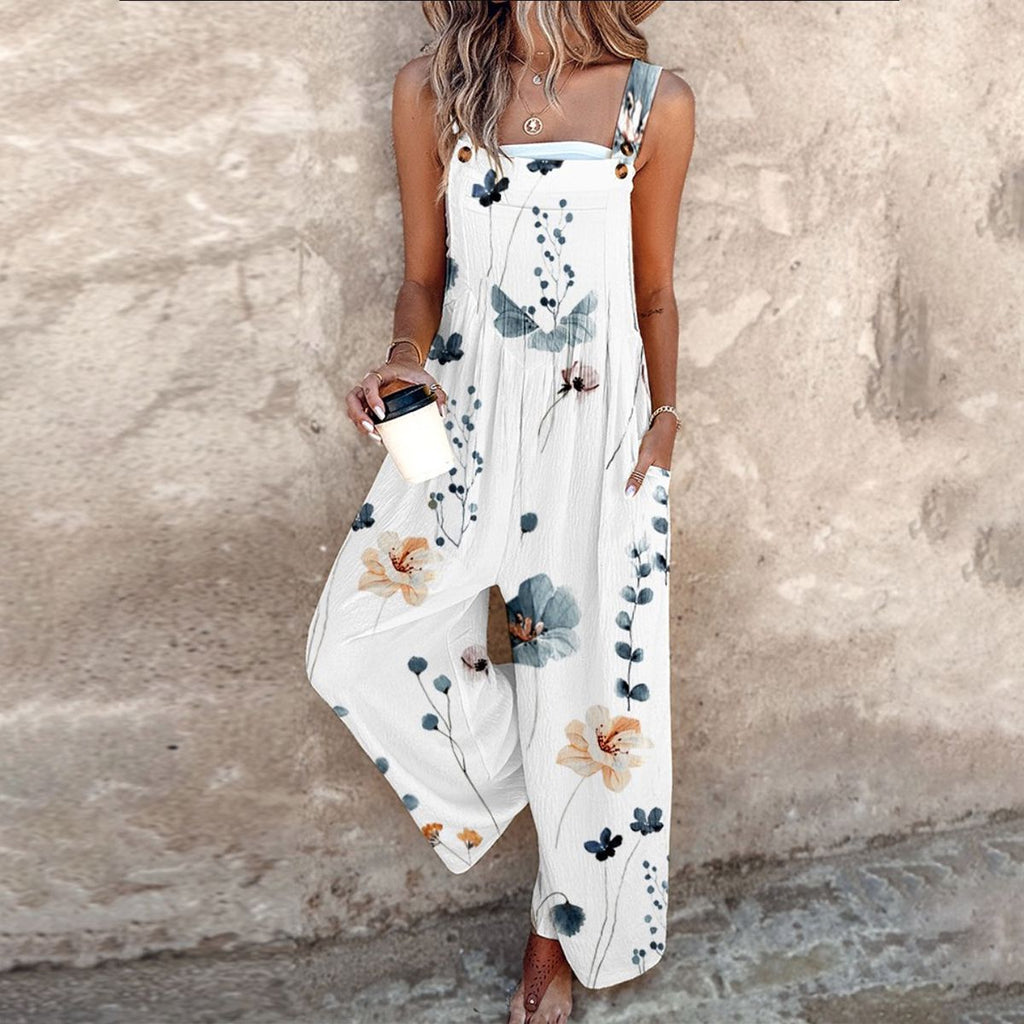 White sleeveless jumpsuit with blue floral and leafy print, wide-leg fit