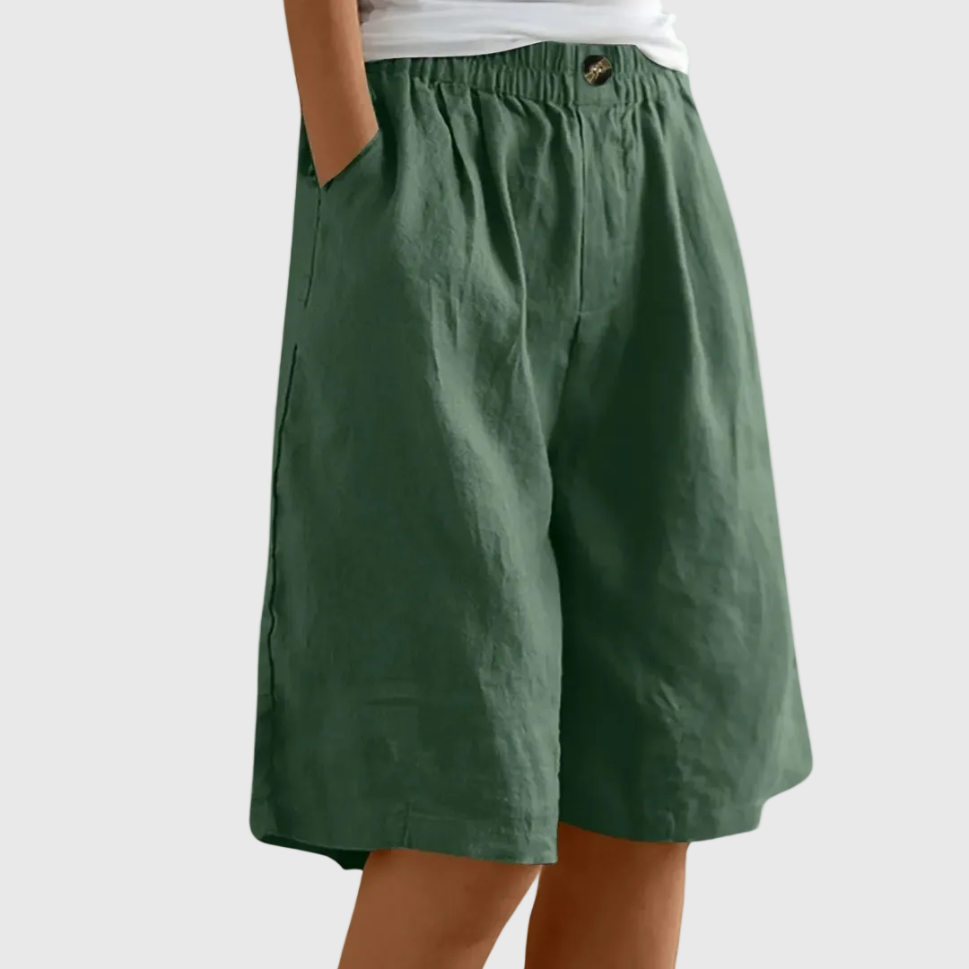 Loose fit elastic waist shorts in dark green, with front seam and button detail at waistband