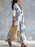 White and blue floral maxi dress with button front, tiered skirt, and puff sleeves