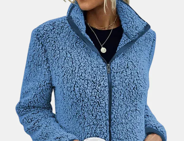 Close-up of blue teddy fleece zip-up jacket with stand collar and zipper