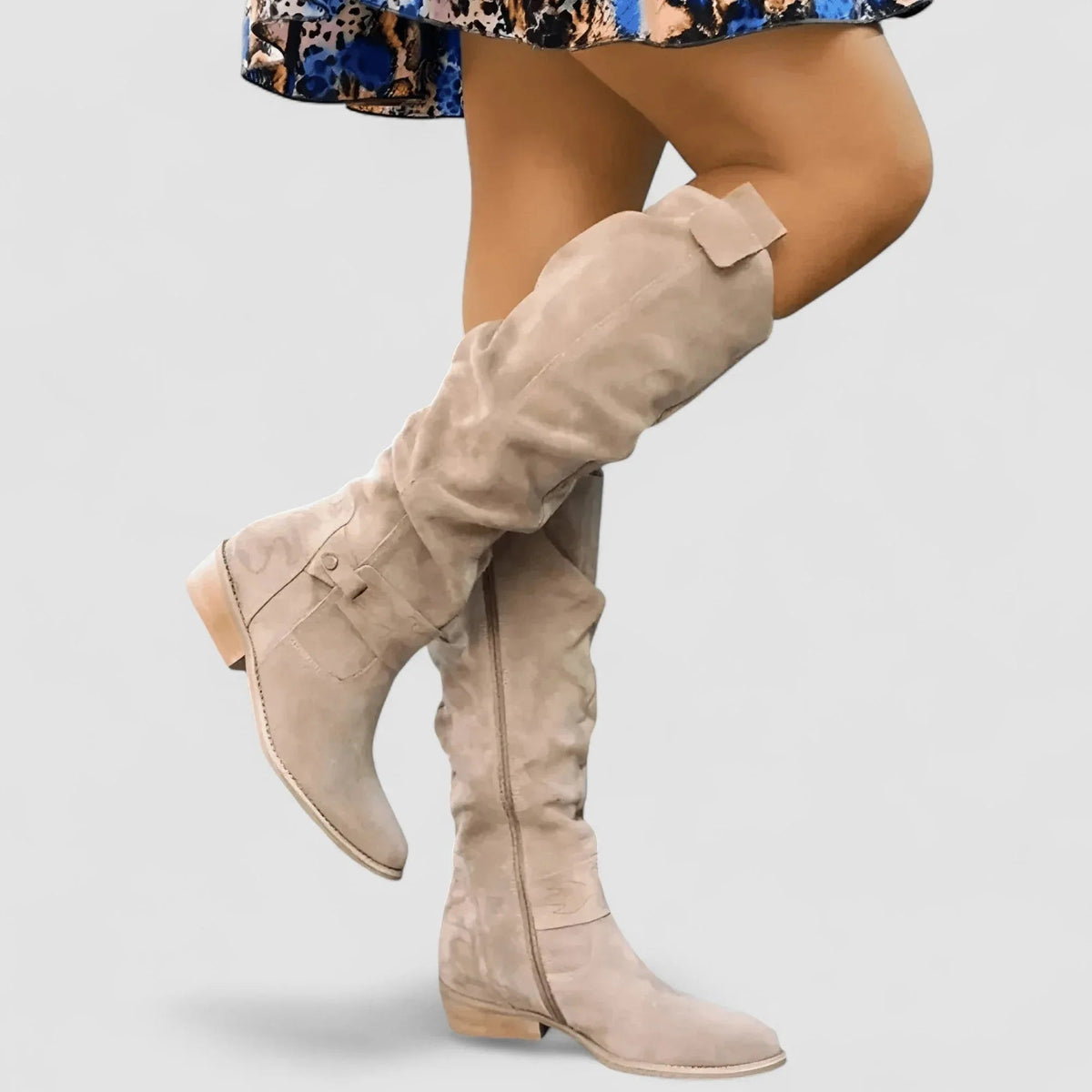 Beige knee-high western boots with side seam and low stacked heel.