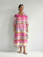 Pink striped tiered midi dress with tassel trim and 3/4 sleeves