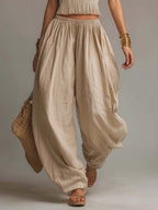 Beige halter two-piece set with fringe crop top and relaxed balloon pants, full length