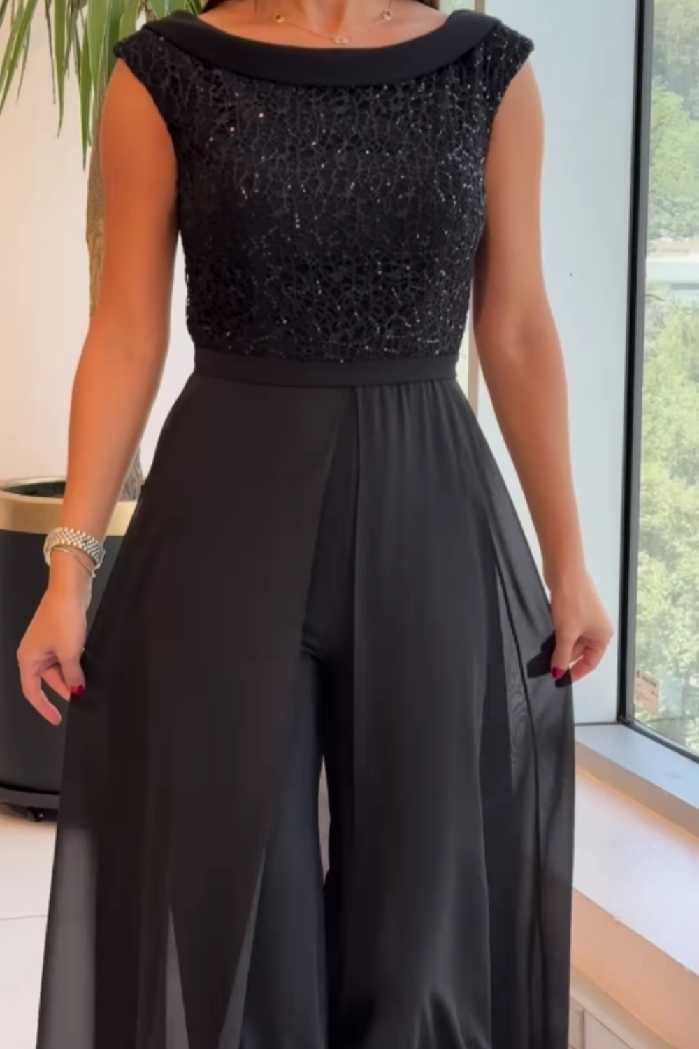 Black sleeveless textured tulle jumpsuit with scoop neck and flowing wide-leg skirt