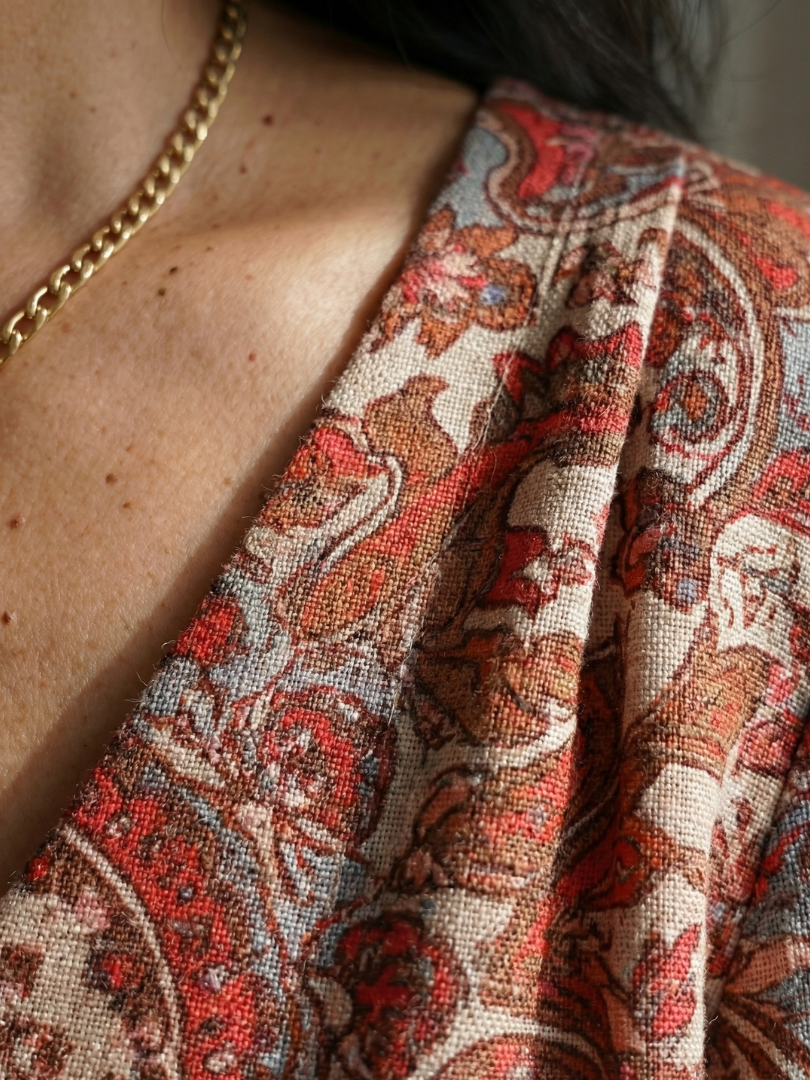 Red and white printed dress fabric detail with decorative border and gathered yoke.