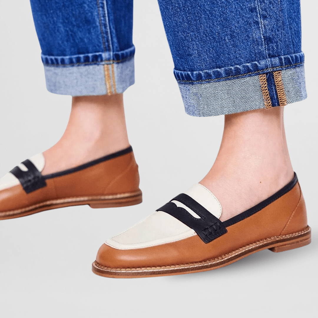 Brown loafers with black strap and white top panel, tan welt and outsole