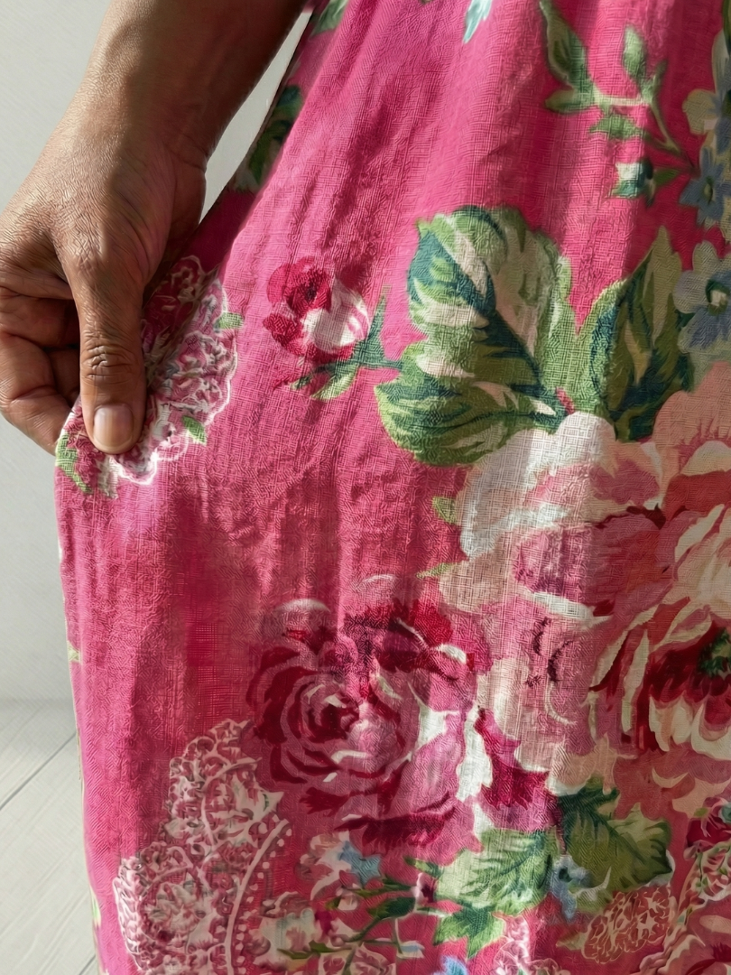 Pink floral midi dress fabric close-up with rose and leaf pattern