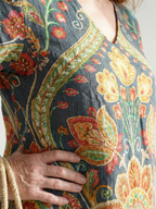 Close-up of floral midi dress fabric: dark teal with multicolor embroidered pattern