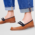 Brown loafer with black strap and white panel, visible tan welt and sole
