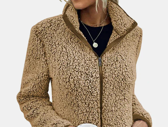 Close-up of beige teddy fleece zip-up jacket with stand collar and zipper