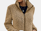 Close-up of beige teddy fleece zip-up jacket with stand collar and zipper