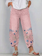 Pink casual trousers with blue-and-white floral embroidery panels on the sides