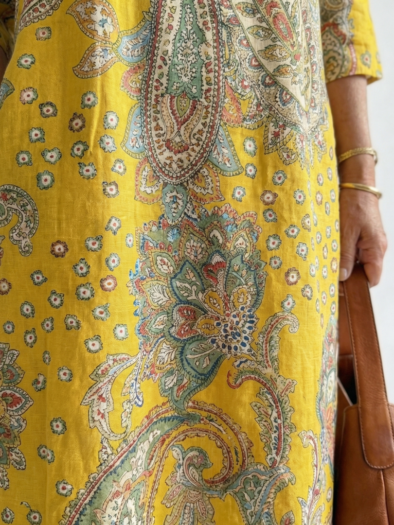 Yellow paisley print midi dress, close-up of V-neck panel
