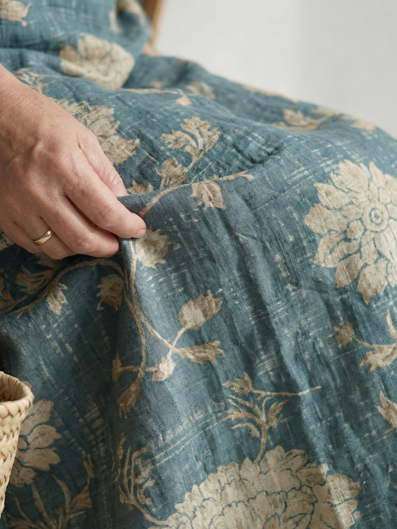 Teal floral midi dress fabric detail with gold motifs and visible stitching