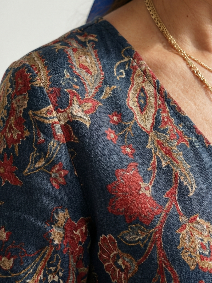 Close-up of blue floral-pattern midi dress fabric with red and tan embroidery