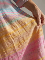 Close-up of pink, blue, and orange gradient striped fabric on midi dress