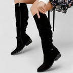Black knee-high western boots with wide cuff strap and low stacked heel.