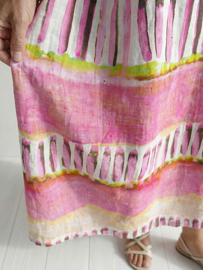 Close-up of pink striped fabric with green-yellow bands and tiered hem trim