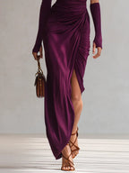 Purple one-shoulder maxi dress with long sleeve, ruched drape, and thigh-high slit