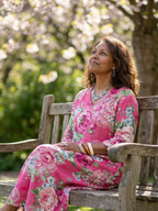 Pink floral midi dress with V-neck, worn while seated