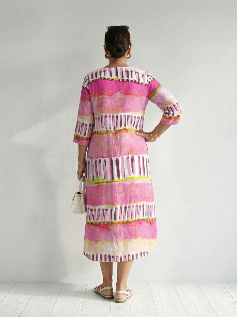 Back view of pink striped tiered midi dress with 3/4 sleeves and tassel trim