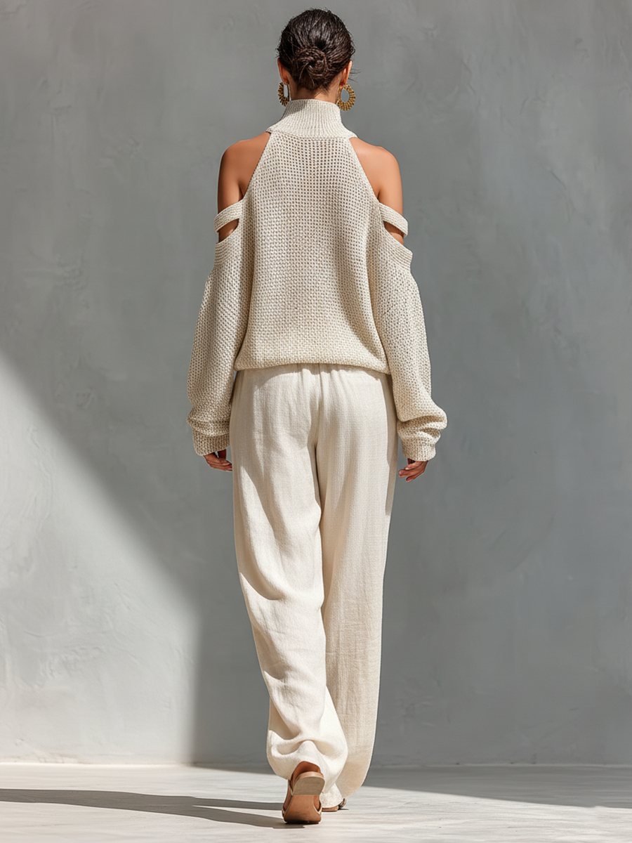 Back of cream knit cold-shoulder turtleneck top with tie-waist wide-leg pants.