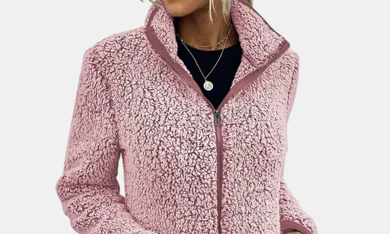 Pink teddy jacket close-up with full-zip front, stand collar, and textured fleece.