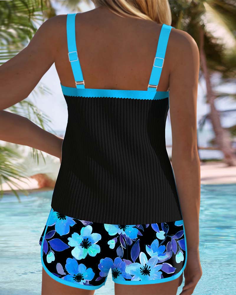 Two-piece tankini back view: black tank top with teal straps and blue floral shorts