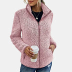 Pink teddy jacket with full-zip front and stand collar, worn with jeans.