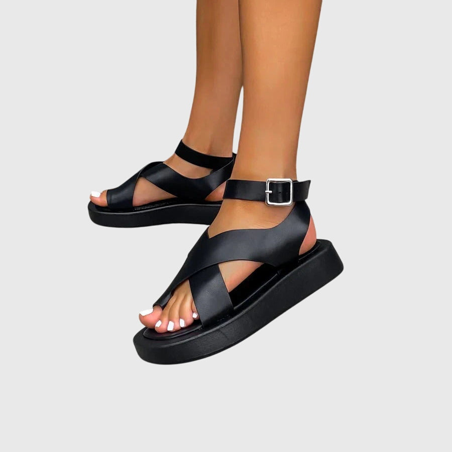 Black orthopedic sandals with cross upper straps and ankle buckle