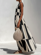Side view of black and white check-and-stripe sleeveless maxi dress with flowy gathered skirt