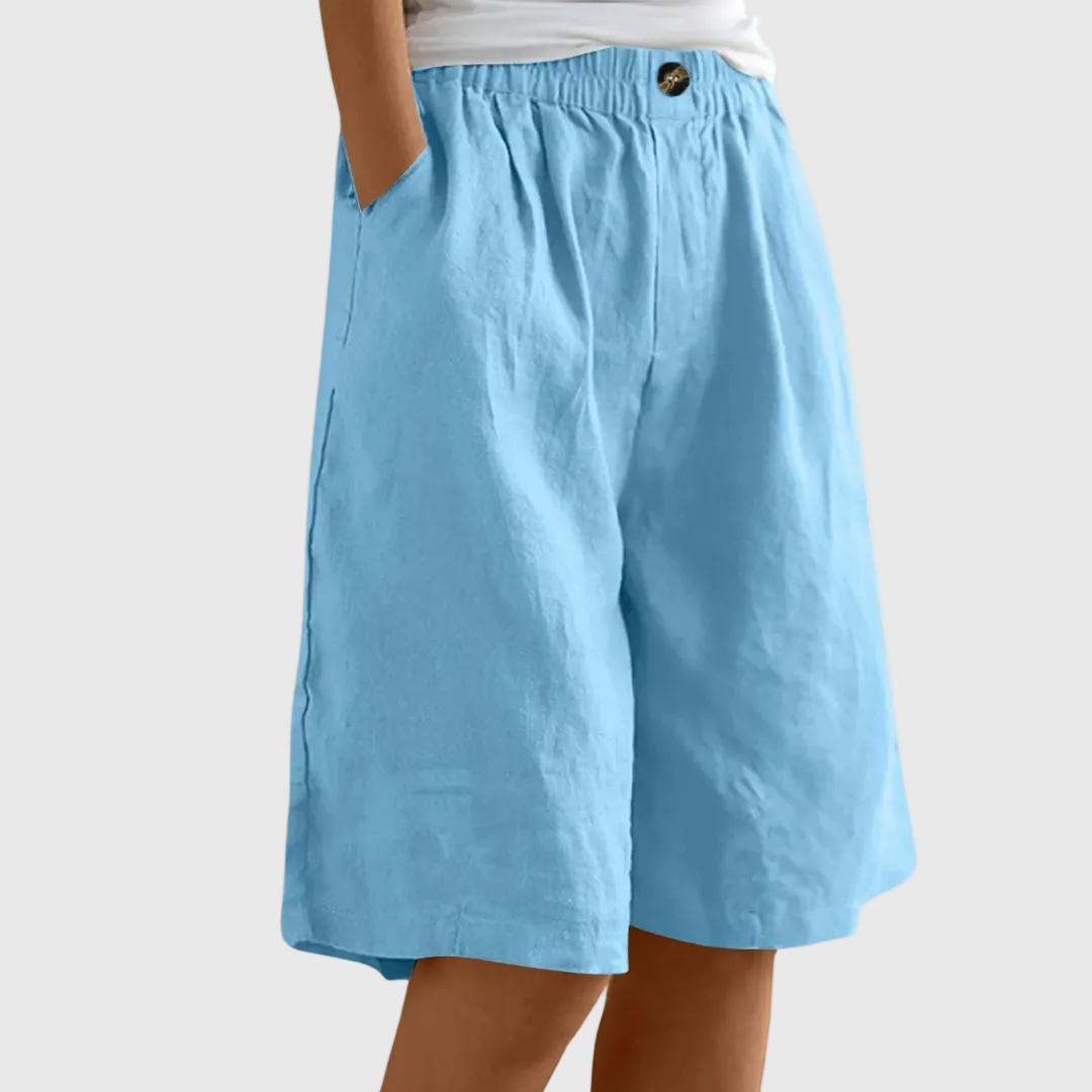 Loose-fit elastic waist shorts in light blue with button detail at waistband