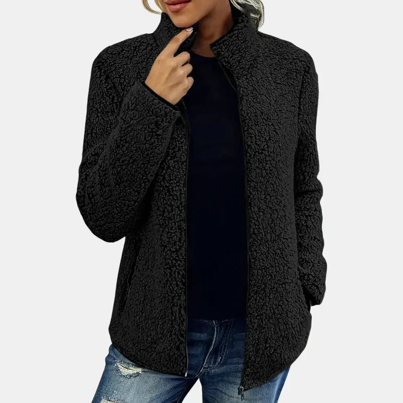 Black teddy jacket with full-zip front and stand collar, worn with jeans.