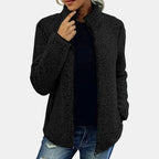 Black teddy jacket with full-zip front and stand collar, worn with jeans.