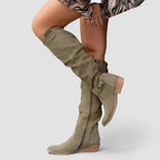 Dark green knee-high western boots with buckle strap and low stacked heel.