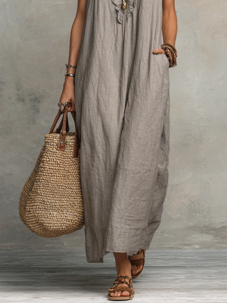 Grey sleeveless maxi dress hem with flowy fabric, close lower view.