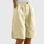 Loose-fit elastic waist shorts in pale yellow with button detail at waistband