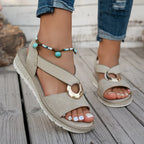 Beige flat sandals with wide strap and round metal buckle, chunky sole