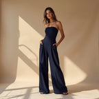 Dark blue strapless wide-leg jumpsuit with fitted bodice and draped waist