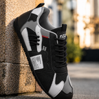 Colorful retro sneaker in black and gray with white side panels and red lace accents