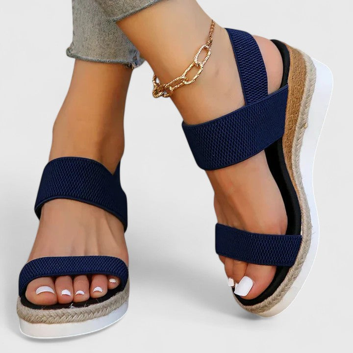 Navy orthopedic sandals with wide straps, tan espadrille sole, and gold chain ankle strap