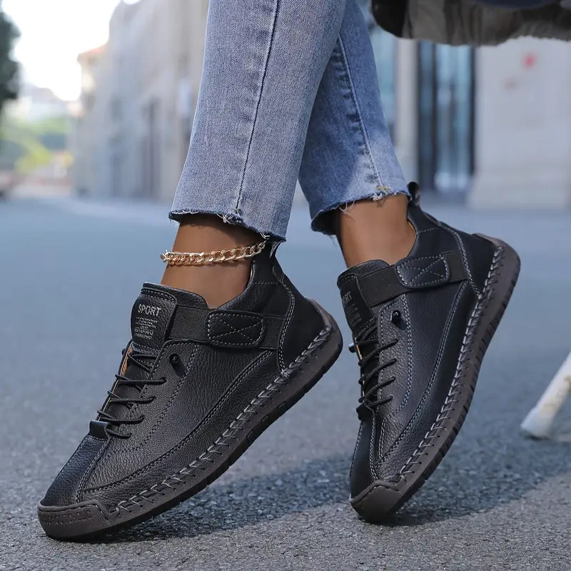 Black comfort support sneaker with lace-up, ankle chain, and textured midsole stitching