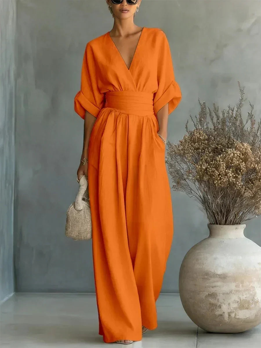 Orange V-neck high-waist jumpsuit with cinched waist and wide-leg flow, dolman sleeves