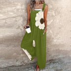 Green sleeveless jumpsuit with large white daisy print and relaxed wide-leg cut